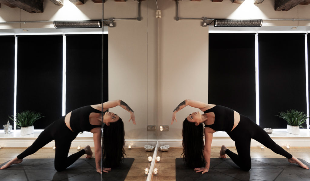 Frau praktiziert Hot Yoga und wird von Herschel erwärmt