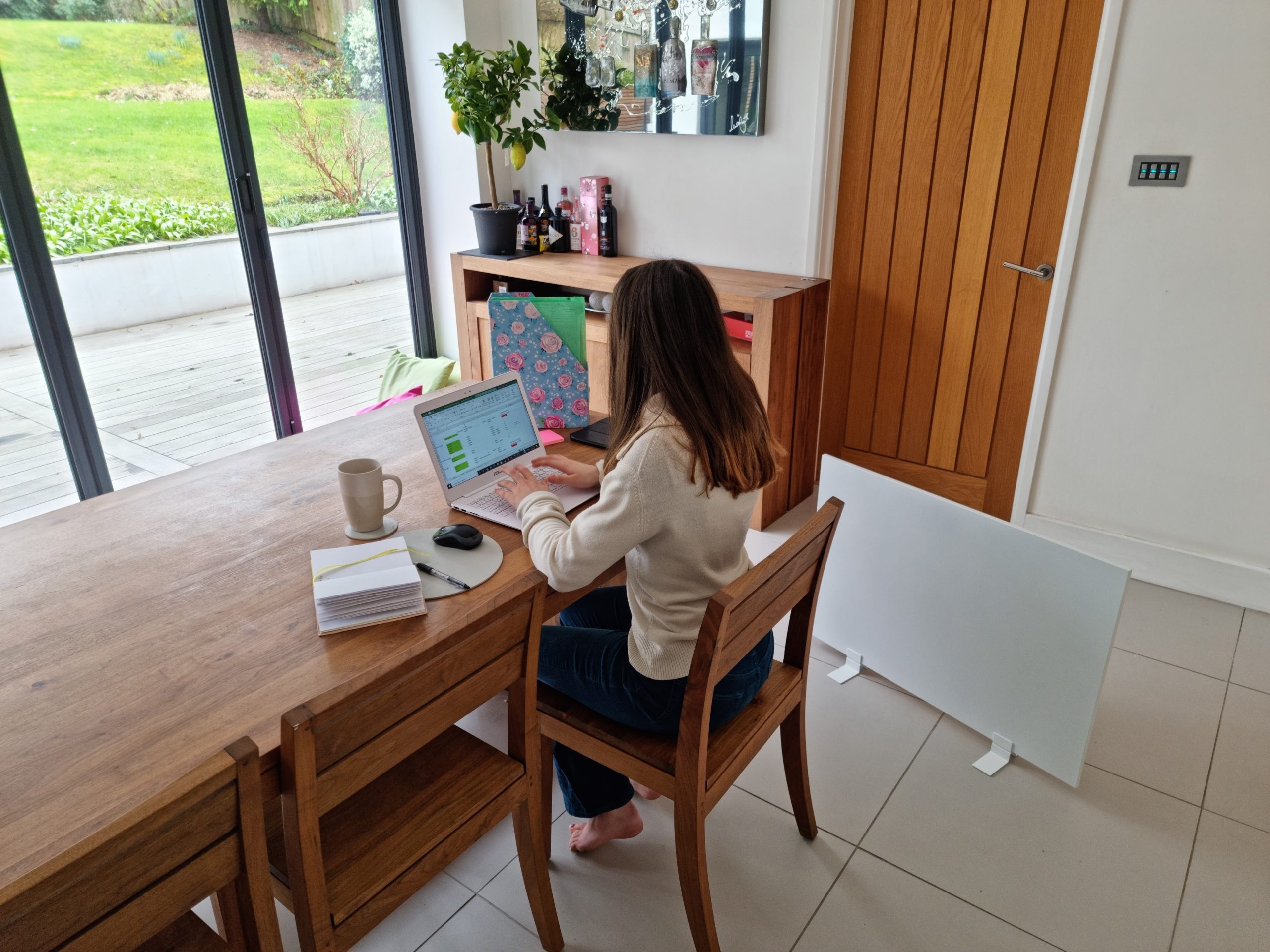 Frau, die von zu Hause aus arbeitet, genießt die Wärme eines tragbaren Herschel-Heizgeräts