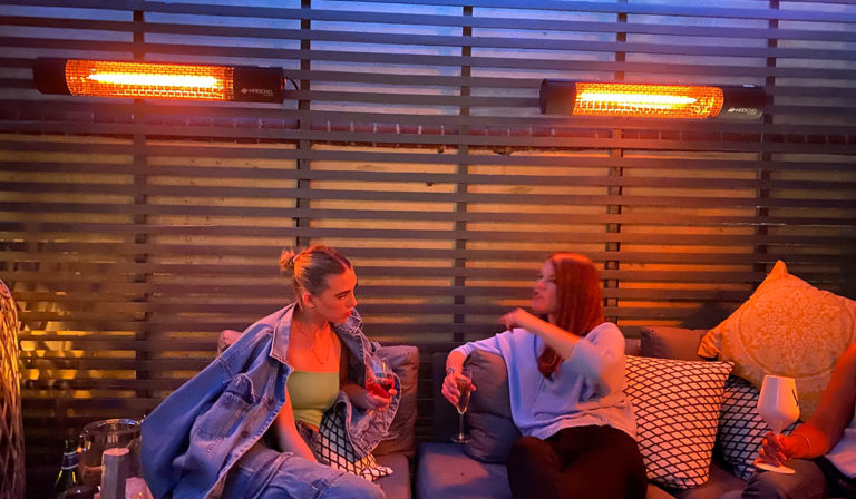 Frauen unterhalten sich auf der von Herschel beheizten Terrasse