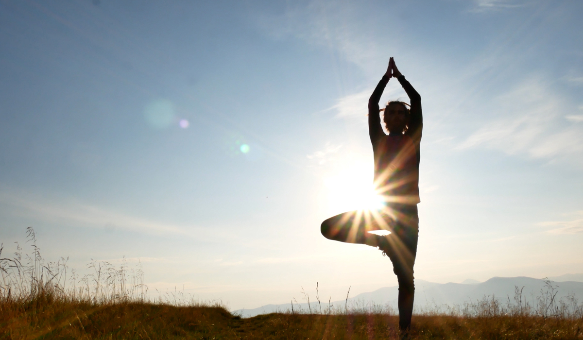 Frau macht im Freien eine Yoga-Pose